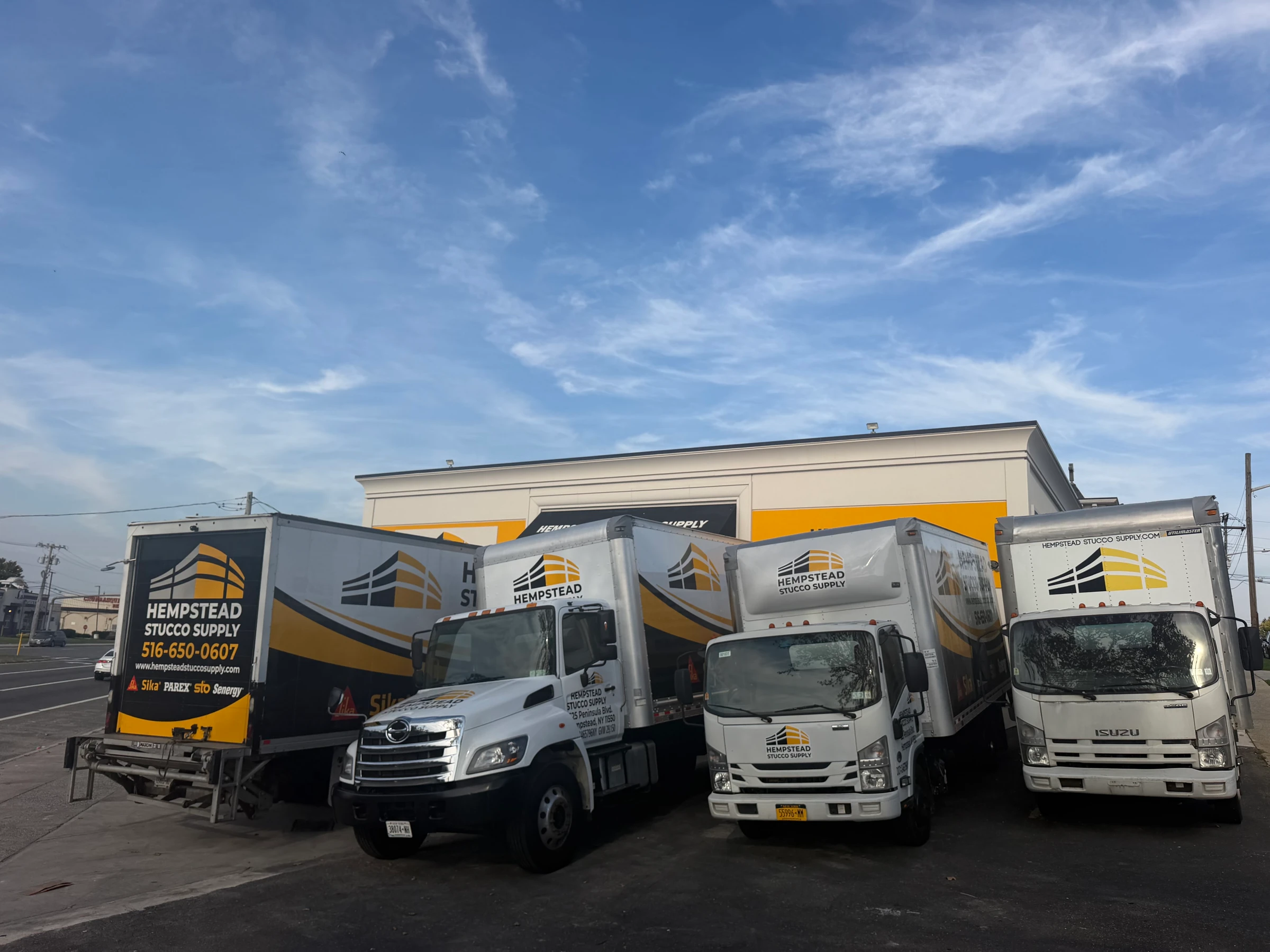 Hempstead Stucco Supply delivery trucks parked in front of the store
