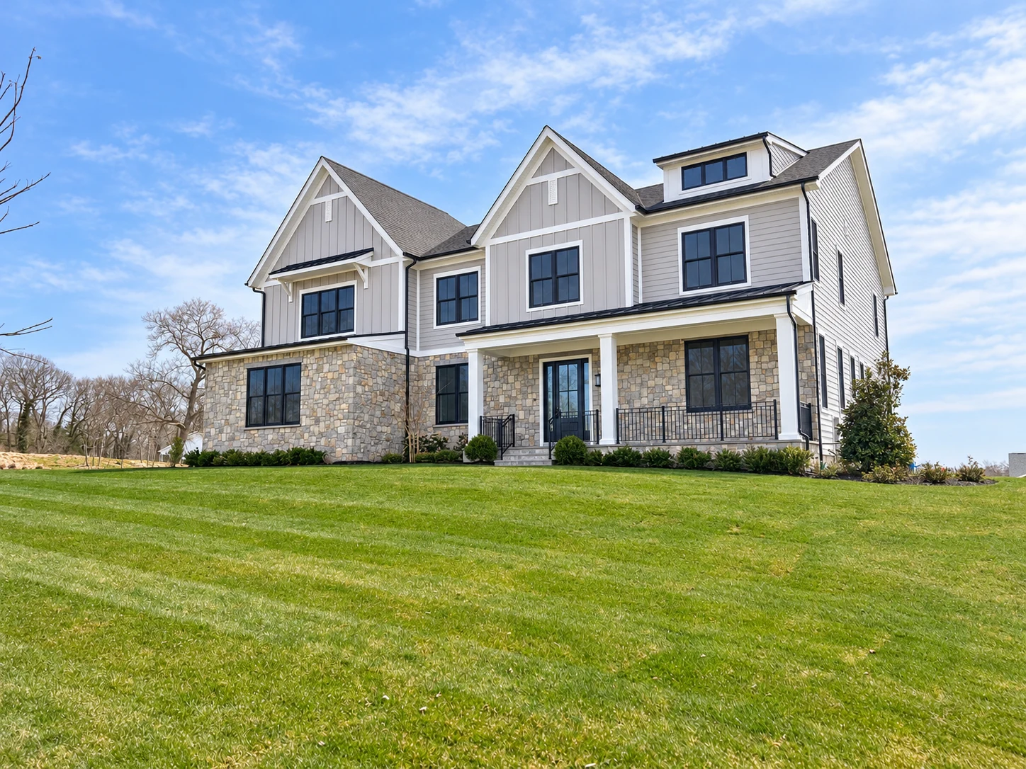 Gabled home with stone walls and gray siding.