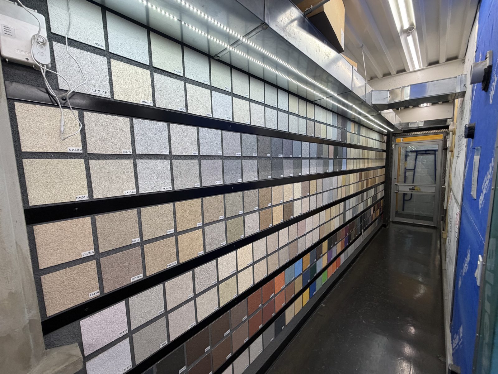 Wall of physical color samples at Hempstead Stucco Supply